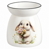 A white ceramic wax warmer with a black rim, featuring a printed illustration of a fluffy white bunny holding a bouquet of pink, yellow, and white flowers.