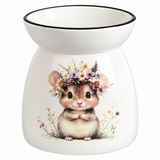 A white ceramic wax warmer or oil burner with a black rim, featuring a printed illustration of a cute brown and white hamster wearing a colorful flower crown on the front.