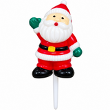 A Santa Claus figurine mounted on a white stick, shown against a plain white background. The Santa figure is wearing a red suit with white trim, black boots and belt, green gloves, and has a white beard and red hat.