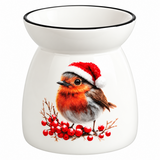 A white ceramic Christmas oil burner featuring a printed illustration of a robin bird wearing a red Santa hat and perched on a branch with red berries, set against a plain white background.