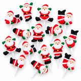 A set of Santa Claus figure cake topper picks arranged on a plain white background. Each pick features a small Santa figure with a red and white striped suit, white beard, green gloves, and black boots, mounted on a white stick.