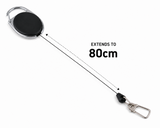 A retractable clip with a black oval reel and silver metal hardware, shown on a white background with a dotted line and text reading 'EXTENDS TO 80cm'.