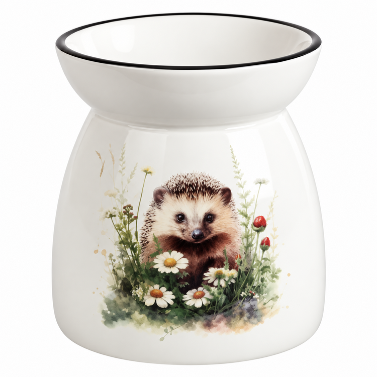 A white ceramic oil burner or scented candle holder with a black rim, featuring a printed illustration of a hedgehog surrounded by daisies, clovers, and red berries on a white background.