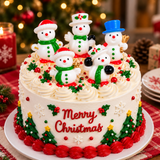A decorated Christmas cake with four snowman figurines, red piped frosting borders, green holly and tree motifs, and the words 'Merry Christmas' on the front, set on a plate with festive candles and ornaments in the background.