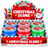 A retail display box of Christmas-themed slime containing six small plastic jars in blue, red, and green, with a festive red and white header and front panel reading 'Merry Christmas Christmas Slime' and '24 PCS'.