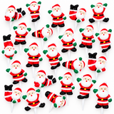 A sheet of small Santa Claus cake toppers, shown against a plain white background. The Santa figures are decorated in the classic red and white suit with black boots, and green gloves and beard accents.