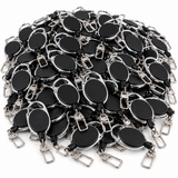 A bulk pile of black oval retractable badge reel keychains with silver metal clips and rings, arranged on a plain white background.