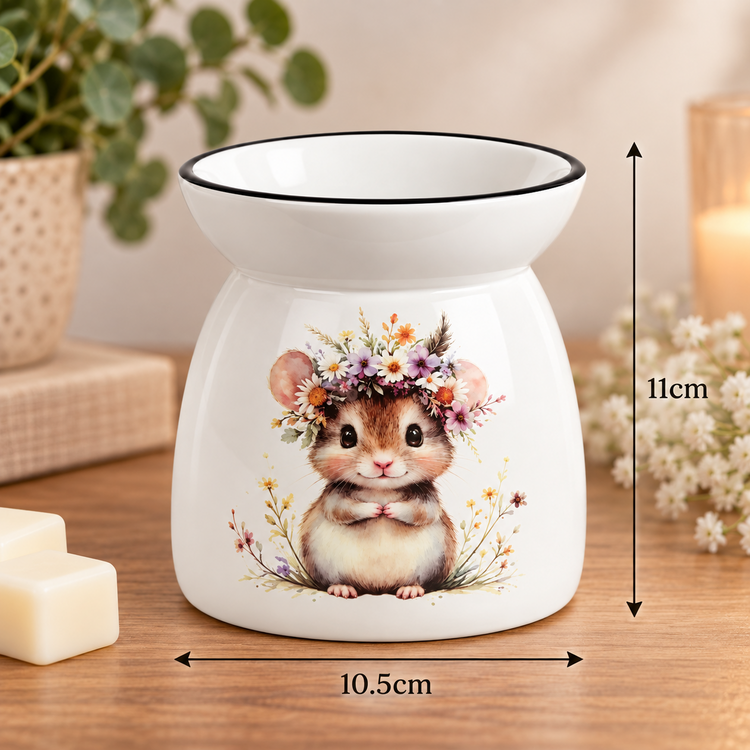A white ceramic wax warmer with a printed cute hamster wearing a floral crown, shown on a wooden surface with dimension arrows indicating 11 cm height and 10.5 cm width.