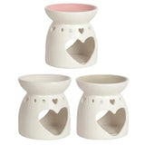 Set of three white ceramic oil burners with heart designs on a white background