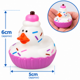A cupcake-shaped rubber duck toy with a white frosting top, pink cupcake base, orange beak, and multicolored sprinkles, shown with blue dimension arrows indicating 6 cm height and 5 cm width. A circular inset shows the toy being held in a hand.