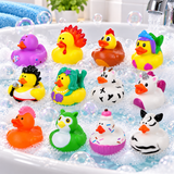 A set of colorful novelty rubber ducks floating in a bathtub filled with soapy bubbles and running water. The ducks include designs like a purple duck with an orange beak, a yellow rooster with red feathers, a brown chicken, a duck wearing a blue fish hat, a duck with black hair holding a phone, a yellow duck with a purple flower headband, a black-and-white cow, a purple-and-white horse, an orange duck, a green owl, a cupcake duck, and a zebra.