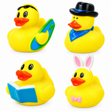 Four yellow rubber duck toys arranged in a 2x2 grid on a white background. One duck holds a green and blue surfboard, one wears a black hat and blue scarf, one reads a blue book, and one wears bunny ears and a pink bow tie.
