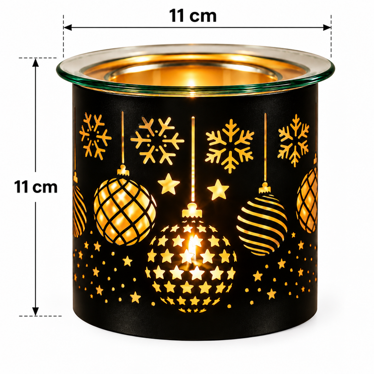 A black cylindrical wax warmer with a festive holiday cutout pattern featuring gold snowflakes, stars, and hanging ornaments. The top rim is clear glass, and a warm light glows through the cutouts.