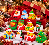 A set of Christmas-themed rubber duck toys displayed in and around a red gift box on a snowy surface with holiday decorations. The ducks are decorated with festive holiday outfits including Santa Claus, snowman, elf, reindeer, and Christmas tree designs.