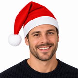 A smiling man wearing a red and white Santa hat against a plain white background.