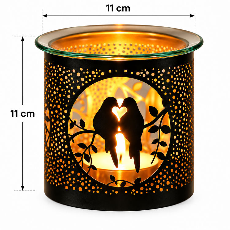 Black metal candle holder with laser-cut bird and heart silhouette design, illuminated with warm orange light inside. Features dimension annotations showing 11 cm height and width on a white background.