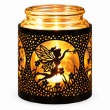 A glass jar candle holder with a black decorative sleeve featuring a silhouette of a fairy and flowers, glowing warmly from an internal candle on a white background.