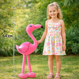 Inflatable pink flamingo toy held by a young girl outdoors with a measurement stick indicating its height.