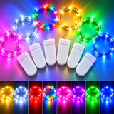 Multicolor solar string lights with white battery-powered controllers, shown in a circular arrangement with a row of white controller units below. The bottom strip shows the lights glowing in multiple colors including yellow, blue, red, pink, green, and purple.