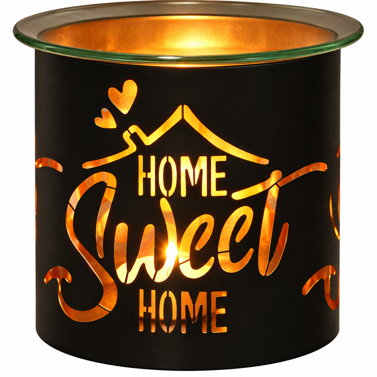 A black metal candle warmer with a glass top rim, illuminated from within to show a warm orange glow. The front features a cutout design with the words 'HOME Sweet HOME' and a house outline with hearts.
