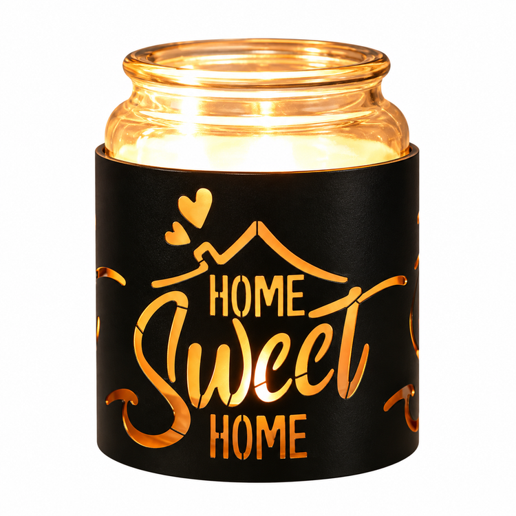 A lit scented candle in a clear glass jar with a black sleeve featuring the phrase 'HOME Sweet HOME' in gold lettering, shown on a plain white background.