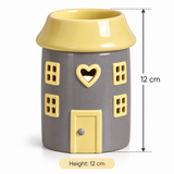 A ceramic house-shaped container or candle holder in gray and yellow, shown on a white background with dimension lines indicating a height of 12 cm.