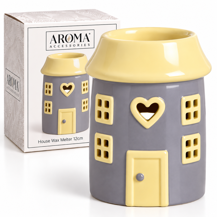 A house-shaped ceramic house wax melter by Aroma Accessories, featuring a gray body and pale yellow roof, windows, door, and heart-shaped cutout, shown next to its product box.