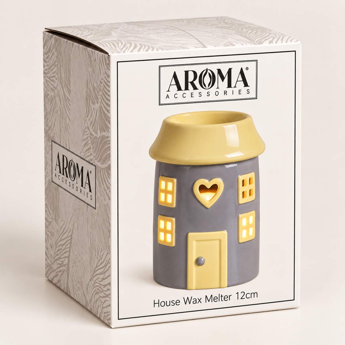 Aroma Accessories house-shaped wax warmer in its retail box. The ceramic house has a gray body, yellow roof, yellow windows, and a yellow door with a heart-shaped cutout.