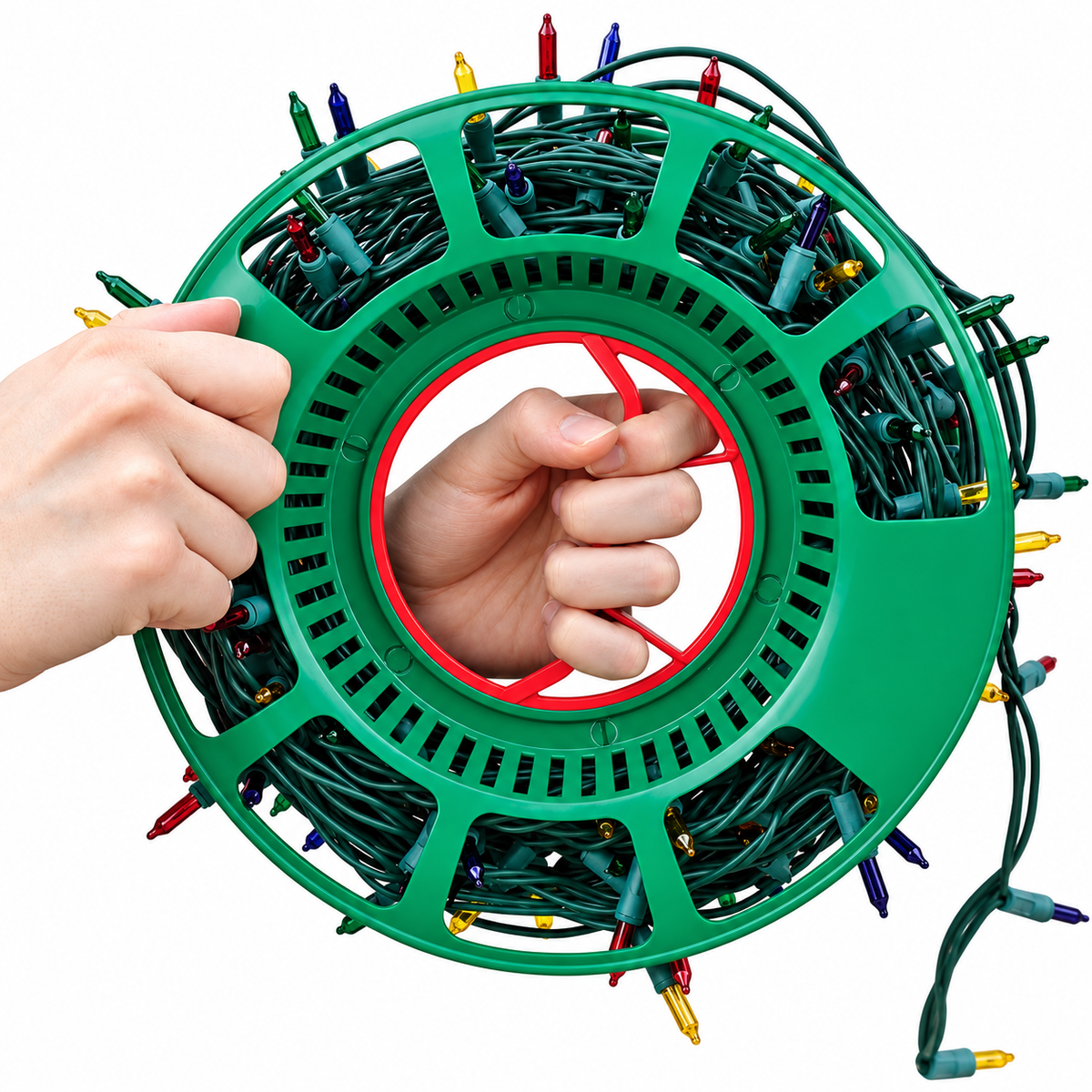 A green plastic Christmas string light reel wrapped with multicolored holiday lights, shown on a white background with two hands holding the reel open.