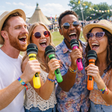 Four friends at a music festival holding colorful microphones and smiling.