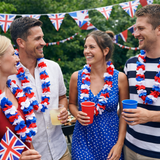 Group of people with red, white, and blue decorations and drinks, likely celebrating a festive occasion.