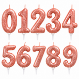 A set of glittery rose gold number candles from 0 to 9, arranged in two rows on a plain white background.