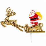 A Christmas-themed plastic cake topper featuring a shiny gold sleigh and reindeer, with a small Santa Claus figurine carrying a yellow sack on the back, mounted on a white stick.