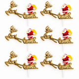 Six Christmas-themed toothpick toppers arranged in a 3-by-2 grid on a white background. Each topper features a gold reindeer pulling a sleigh with Santa Claus seated inside, holding a yellow sack.