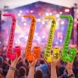 Inflatable saxophones in pink, orange, yellow, and green held by people at a concert.