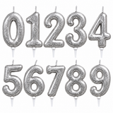 Set of ten silver glitter number candle toppers from 0 to 9, arranged in two rows on a plain white background.