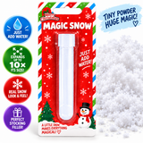 A packaged novelty magic snow tube on a white background with promotional text and snowflake graphics. The product is in blister packaging with a red holiday card-style backing, a white plastic tube, and colorful callout badges on the left.