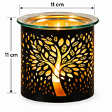 Black metal candle warmer with a tree silhouette cutout design, lit with a warm yellow glow inside a clear glass container, shown with dimension markers indicating 11 cm height and width.