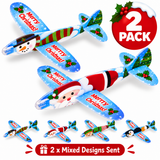 Two Christmas-themed wooden toy airplanes on a white background, one decorated with Santa Claus and the other with a snowman. Smaller examples of other holiday designs are shown along the bottom, with a red '2 PACK' badge and a '2 x Mixed Designs Sent' banner.