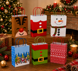Six Christmas-themed paper gift bags arranged on a wooden table in a decorated holiday setting with a Christmas tree, fireplace, ornaments, and candles.