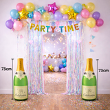 Decorated party arch with colorful balloons, 'PARTY TIME' banner, and two inflatable champagne bottles.