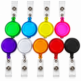 Ten retractable badge reel keychains arranged in two rows on a white background. The reels come in multiple colors including green, blue, yellow, pink, purple, silver, orange, red, black, and clear.