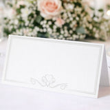 White place card with decorative heart design on a blurred floral background