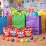 Colorful bags and packages of bouncing putty on a table with a classroom background.